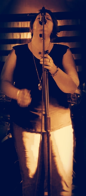 a female singer golds the microphone stand while singing